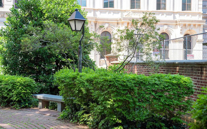 Historic Philadelphia garden with brick path and vintage lamp post.