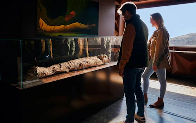 Visitors viewing a mummy exhibit during the Mount Teide Tour with Cable Car Ride.