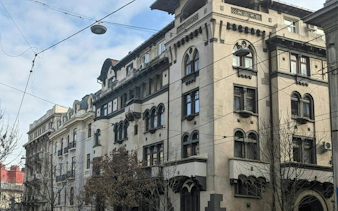 Historic building facade on a street in Bucharest, part of the Theatrical Odyssey city exploration game.