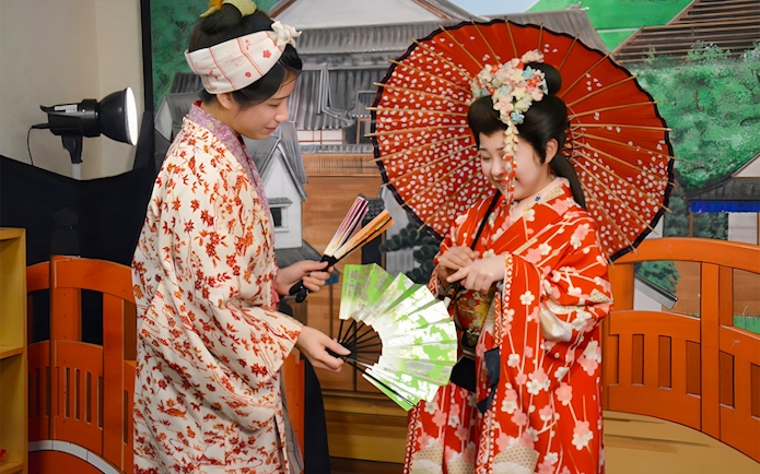 Women in traditional kimonos with fans at Noboribetsu Date Jidaimura, Japan.