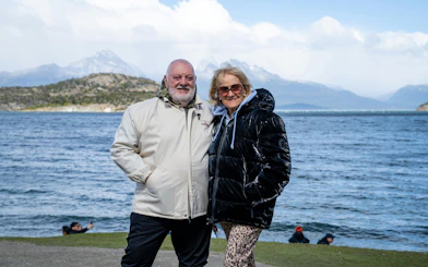 Couple enjoying scenic view at Tierra del Fuego National Park with mountains and lake.