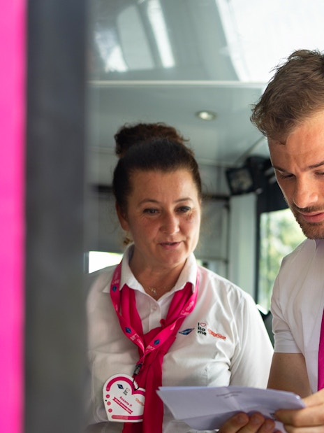 Tour guides assisting a passenger on the I Love Rome Hop-On Hop-Off bus tour.
