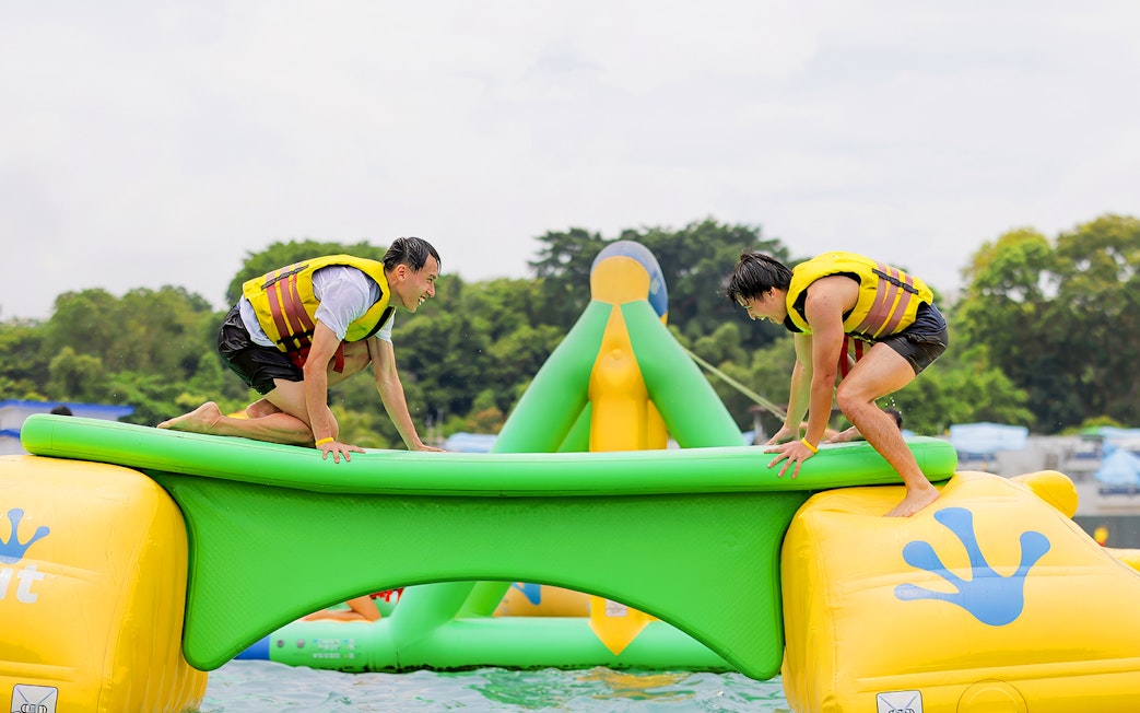 Participants balancing on inflatable obstacle at HydroDash Singapore.