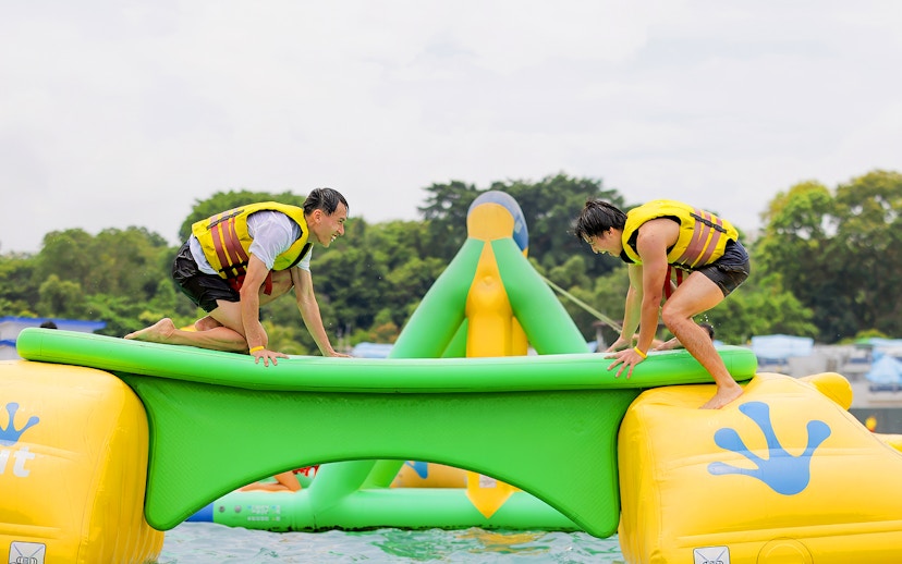 Participants balancing on inflatable obstacle at HydroDash Singapore.