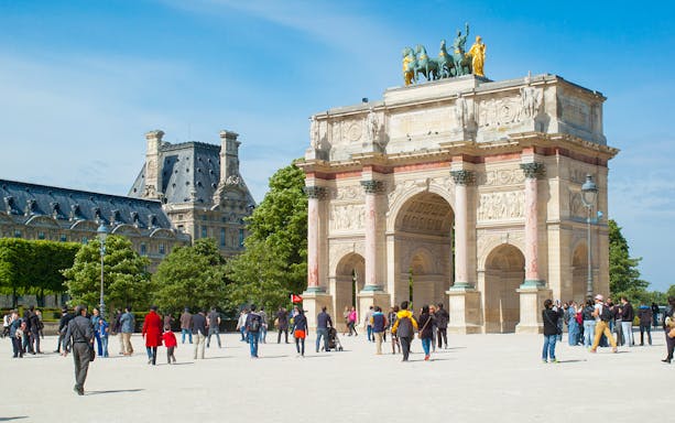 Tourists on a guided walking tour near the Louvre Museum in Paris, France.