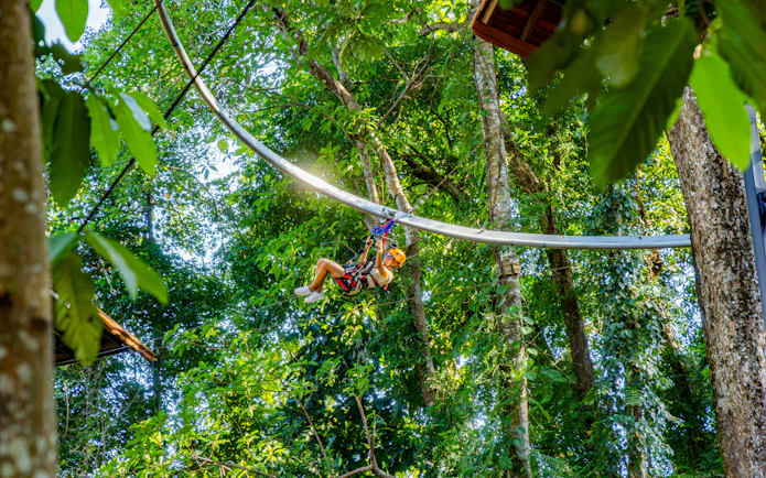 Person ziplining through lush forest on Sky Rock Roller Adventure, Khao Lak.