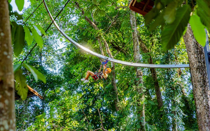 Person ziplining through lush forest on Sky Rock Roller Adventure, Khao Lak.