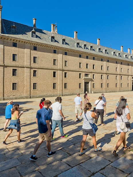 Group of tourists walking towards San Lorenzo de El Escorial in Spain.