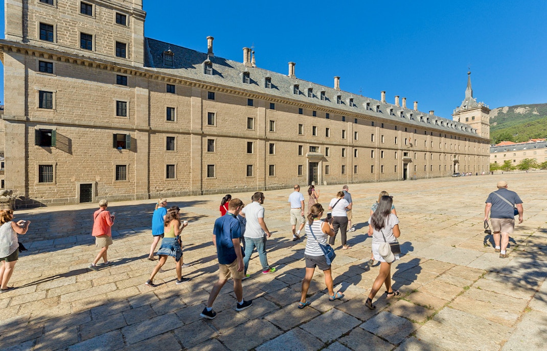 Group of tourists walking towards San Lorenzo de El Escorial in Spain.