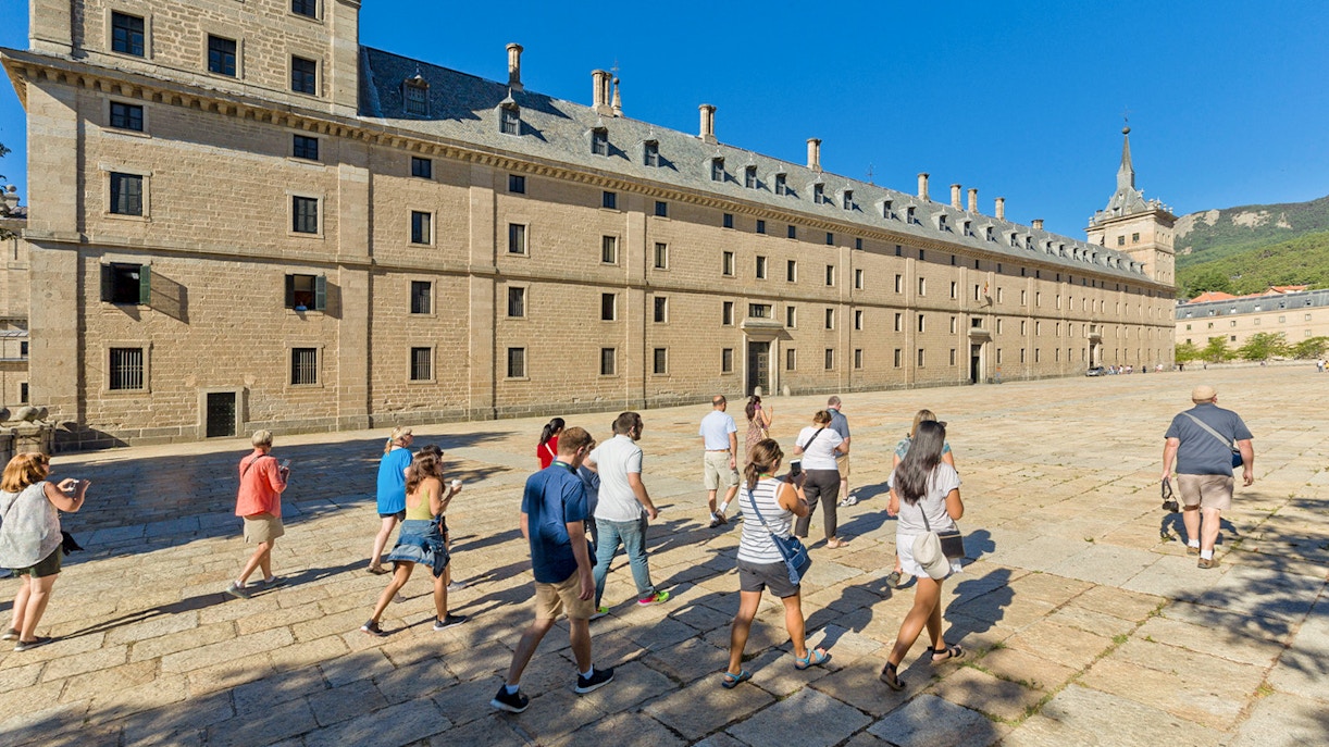 Group of tourists walking towards San Lorenzo de El Escorial in Spain.