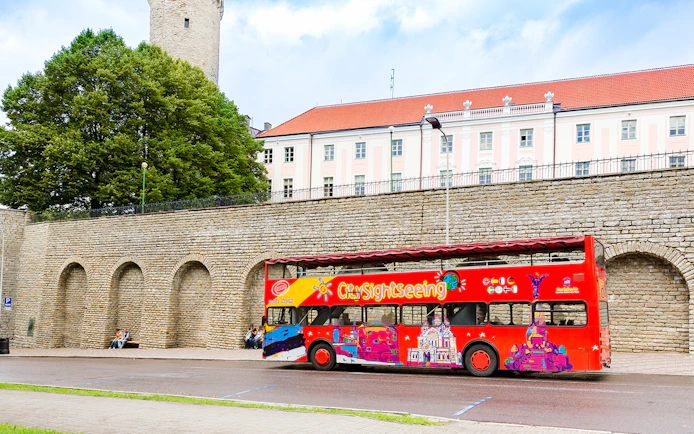 Hop on hop off bus in front of medieval wall in Tallinn, Estonia.