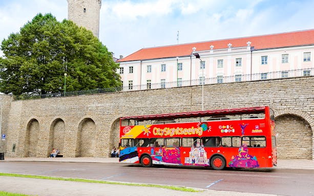 Hop on hop off bus in front of medieval wall in Tallinn, Estonia.