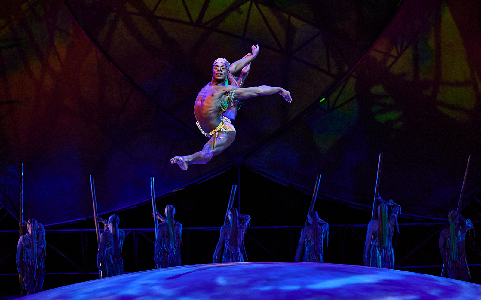 Performer leaping on stage during Mystère show.