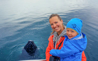 Guests observing a whale in Eyjafjörður, Iceland.