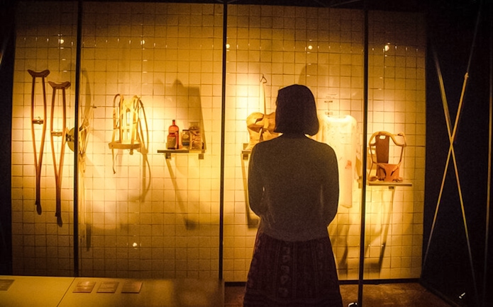 Visitor observing Frida Kahlo's medical artifacts at the Frida Kahlo Museum.