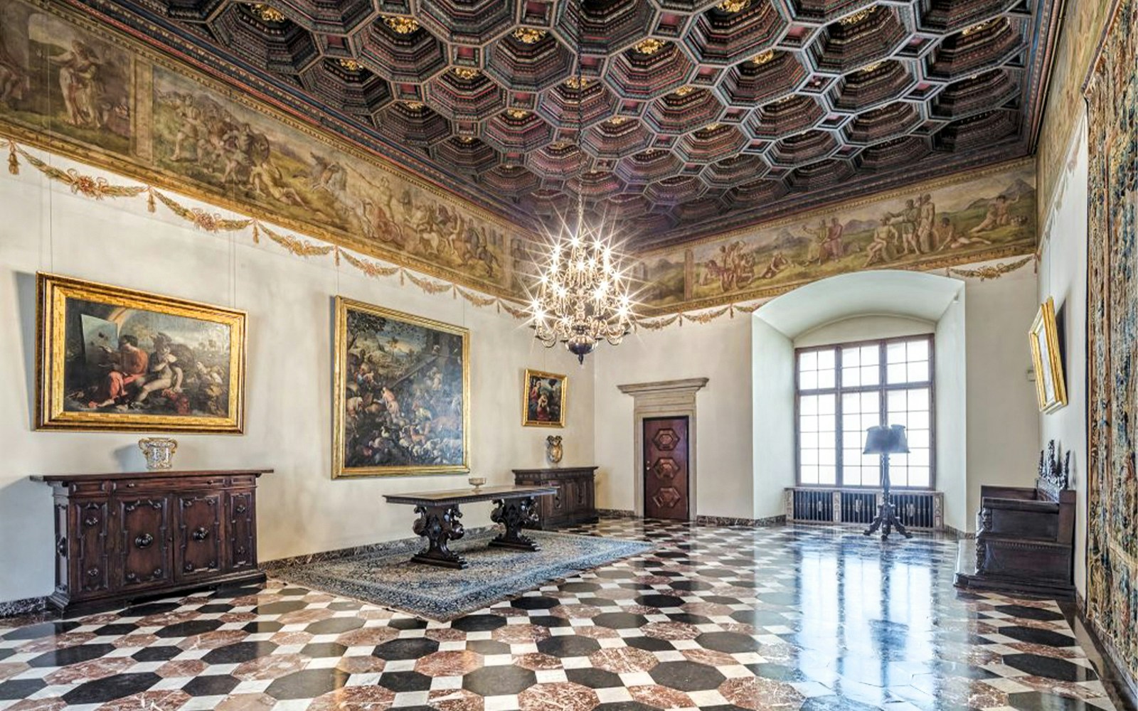 Wawel Castle interior with ornate ceiling, paintings, and chandelier in Krakow.