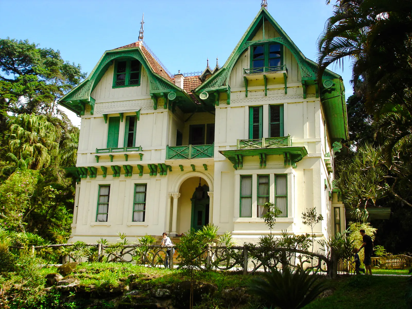 Historic house with green accents in Petrópolis, Rio de Janeiro, surrounded by lush greenery.