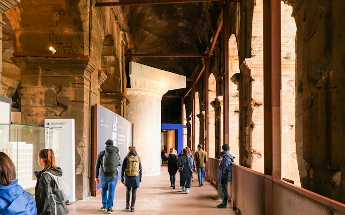 Visitors walking through the Colosseum interior on an express guided tour.