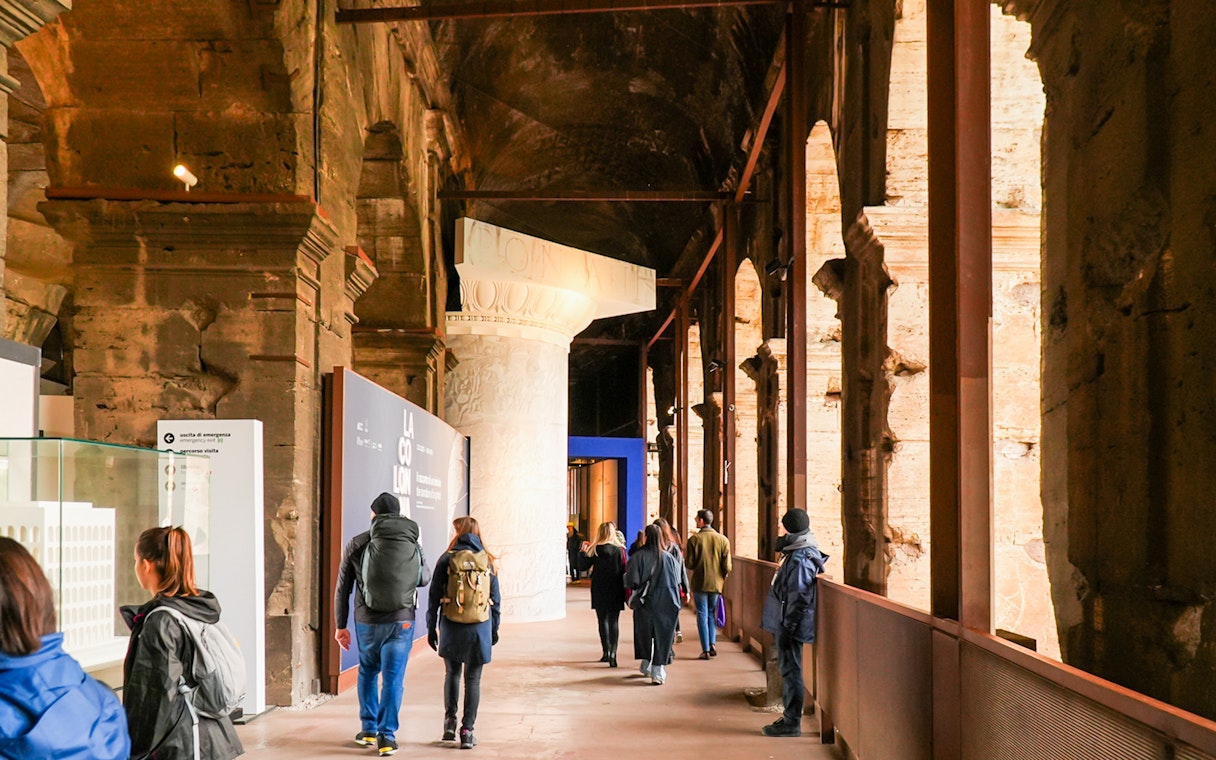 Visitors walking through the Colosseum interior on an express guided tour.