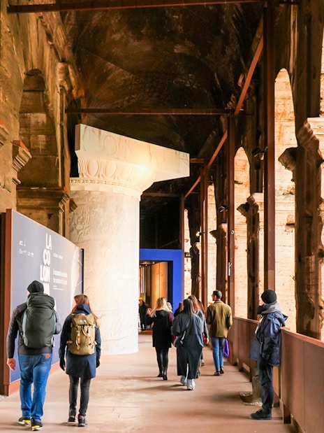 Visitors walking through the Colosseum interior on an express guided tour.