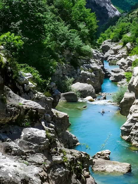 Bovilla Lake canyon with turquoise water and rocky cliffs during exploration hike.