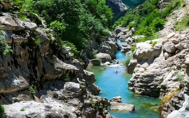 Bovilla Lake canyon with turquoise water and rocky cliffs during exploration hike.