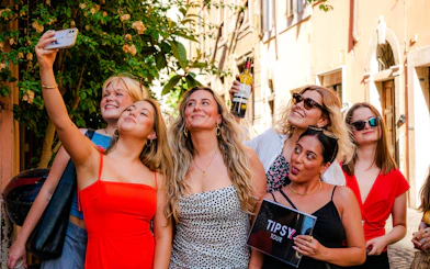 Guests enjoying the Tipsy Tour in Rome, taking a selfie on a charming street.