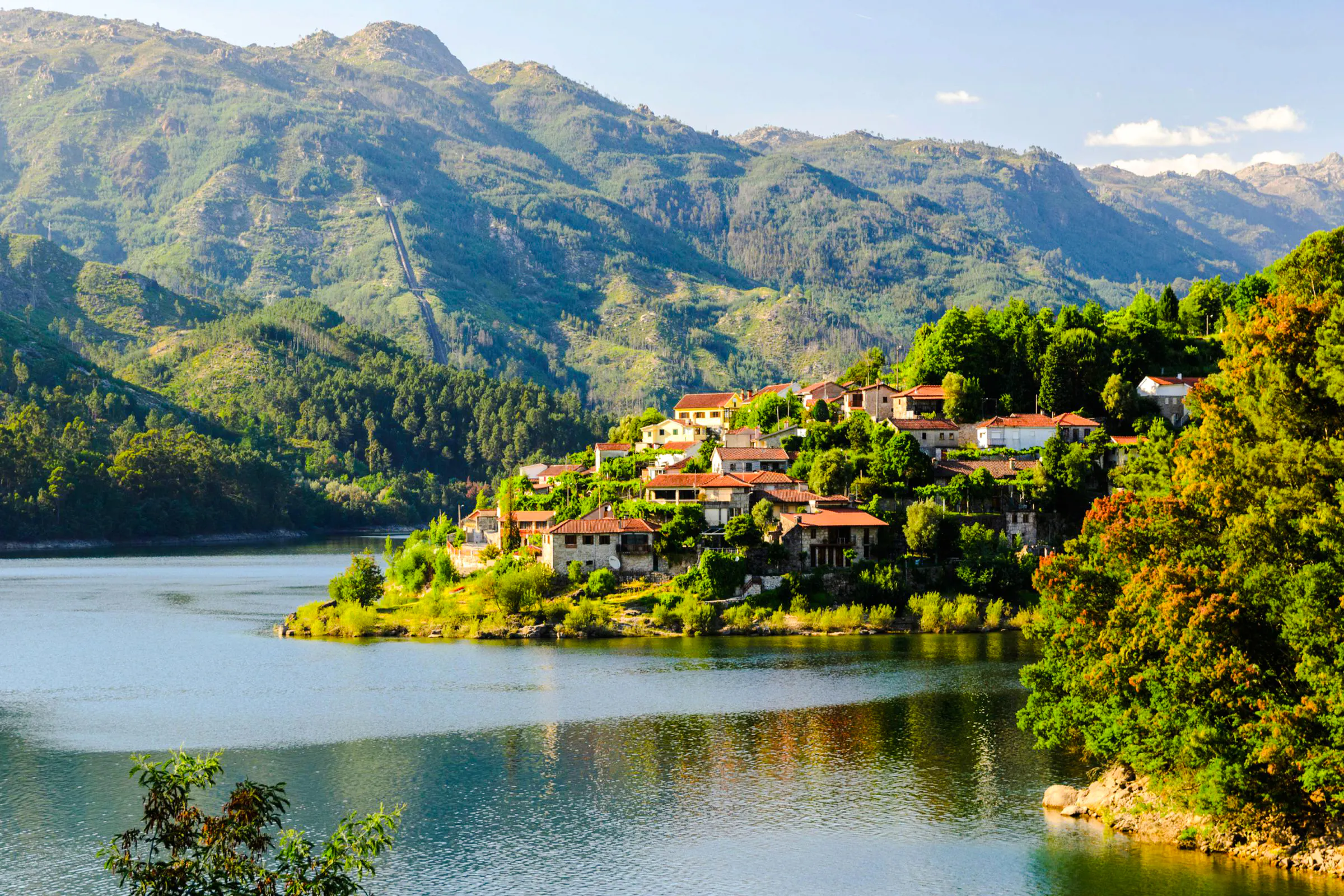 Peneda-Geres National Park village by a lake with mountain backdrop, Porto hiking tour.