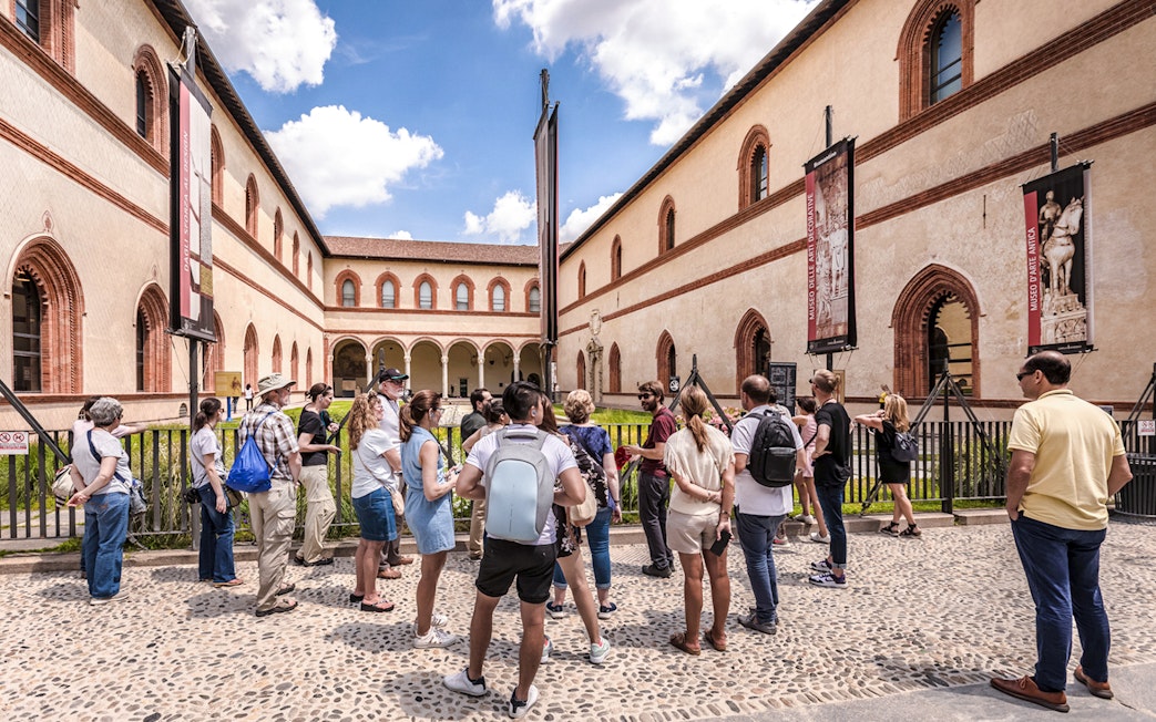 Tour group at Santa Maria delle Grazie, Milan, viewing historical architecture.