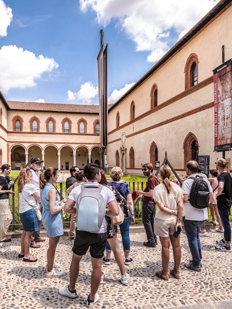 Tour group at Santa Maria delle Grazie, Milan, viewing historical architecture.
