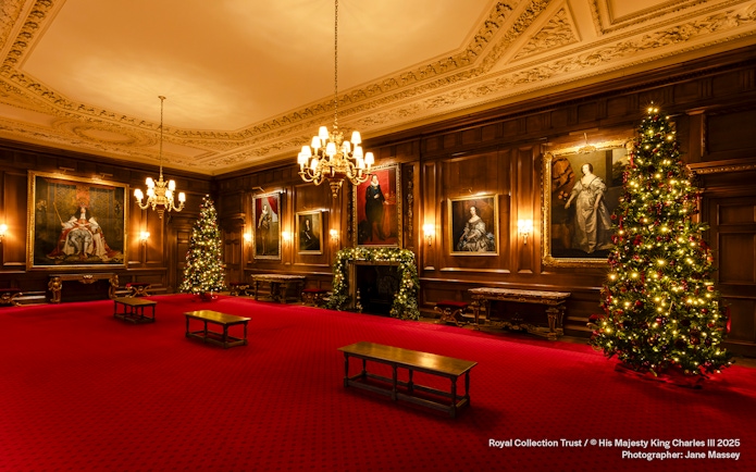 Palace of Holyroodhouse grand room with Christmas trees and portraits.