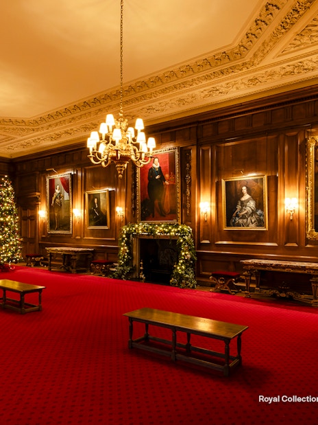 Palace of Holyroodhouse grand room with Christmas trees and portraits.