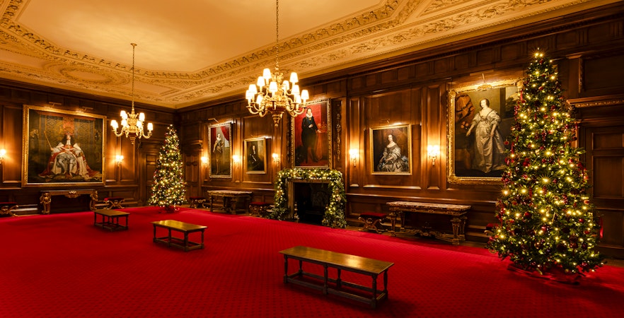 Palace of Holyroodhouse grand room with Christmas trees and portraits.