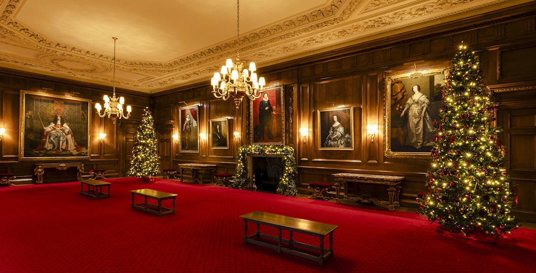 Palace of Holyroodhouse grand room with Christmas trees and portraits.