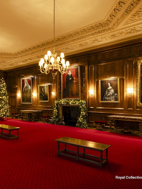 Palace of Holyroodhouse grand room with Christmas trees and portraits.