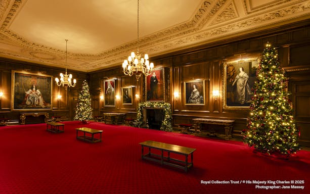 Palace of Holyroodhouse grand room with Christmas trees and portraits.