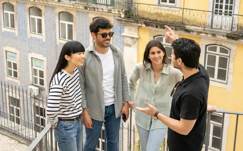 Group of tourists enjoying a guided walking tour in Lisbon's historic center.