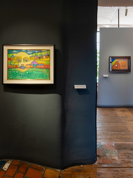 KUNST HAUS WIEN exhibit featuring colorful Hundertwasser paintings on brick walls.