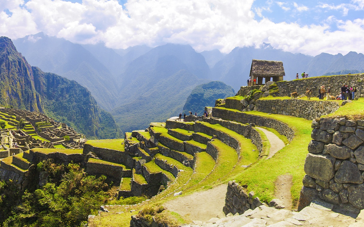 Terraced agriculture area at Machu Picchu with stone structures and mountain backdrop.
