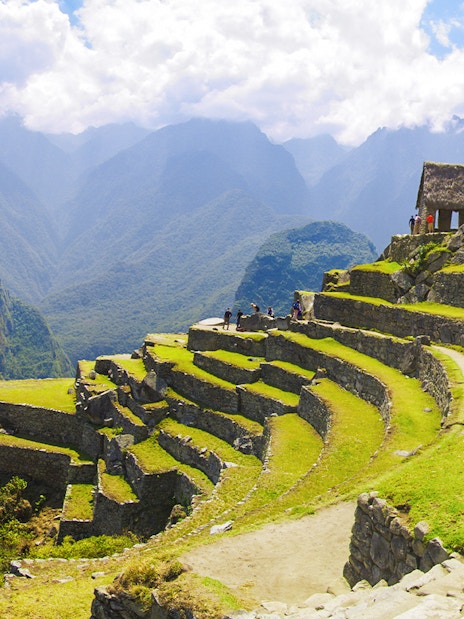 Terraced agriculture area at Machu Picchu with stone structures and mountain backdrop.