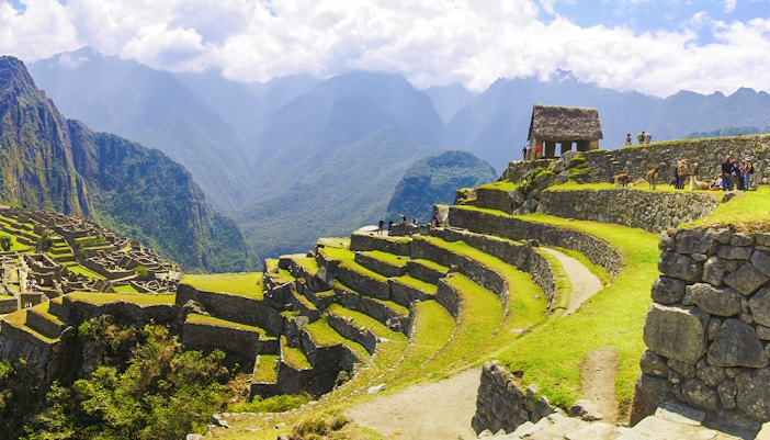 Terraced agriculture area at Machu Picchu with stone structures and mountain backdrop.