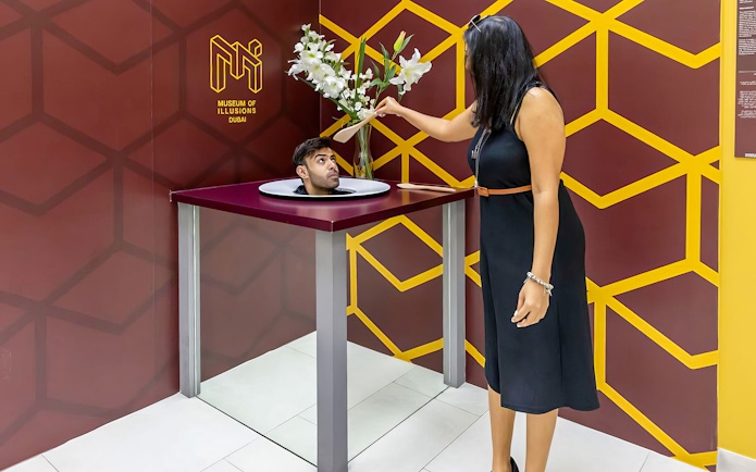 Couple viewing Head on a Platter exhibit at Museum of Illusions, Dubai.