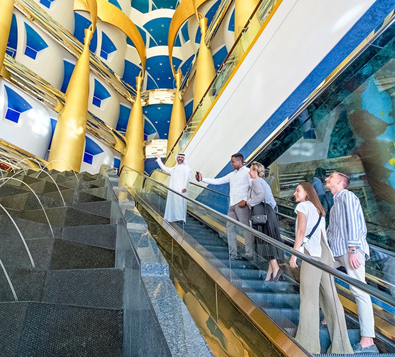 Burj Al Arab interior with opulent decor and grand staircase, Dubai tour experience.