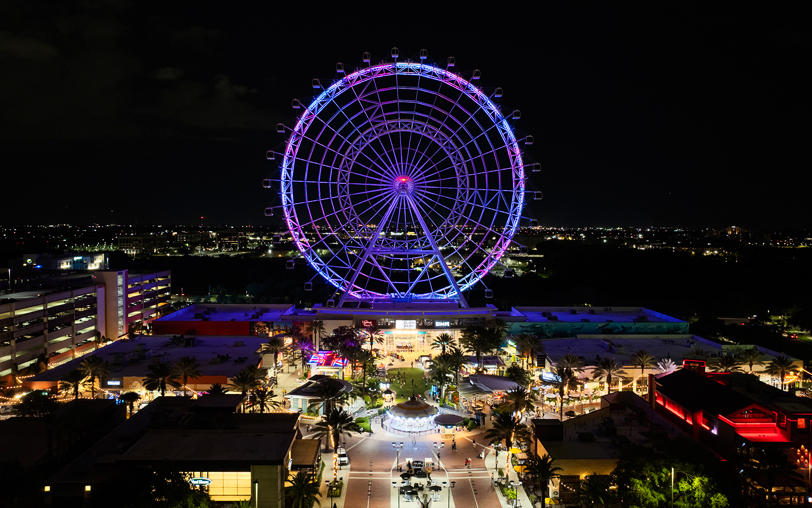 Ferris wheel illuminated at night in ICON Park, Orlando.
