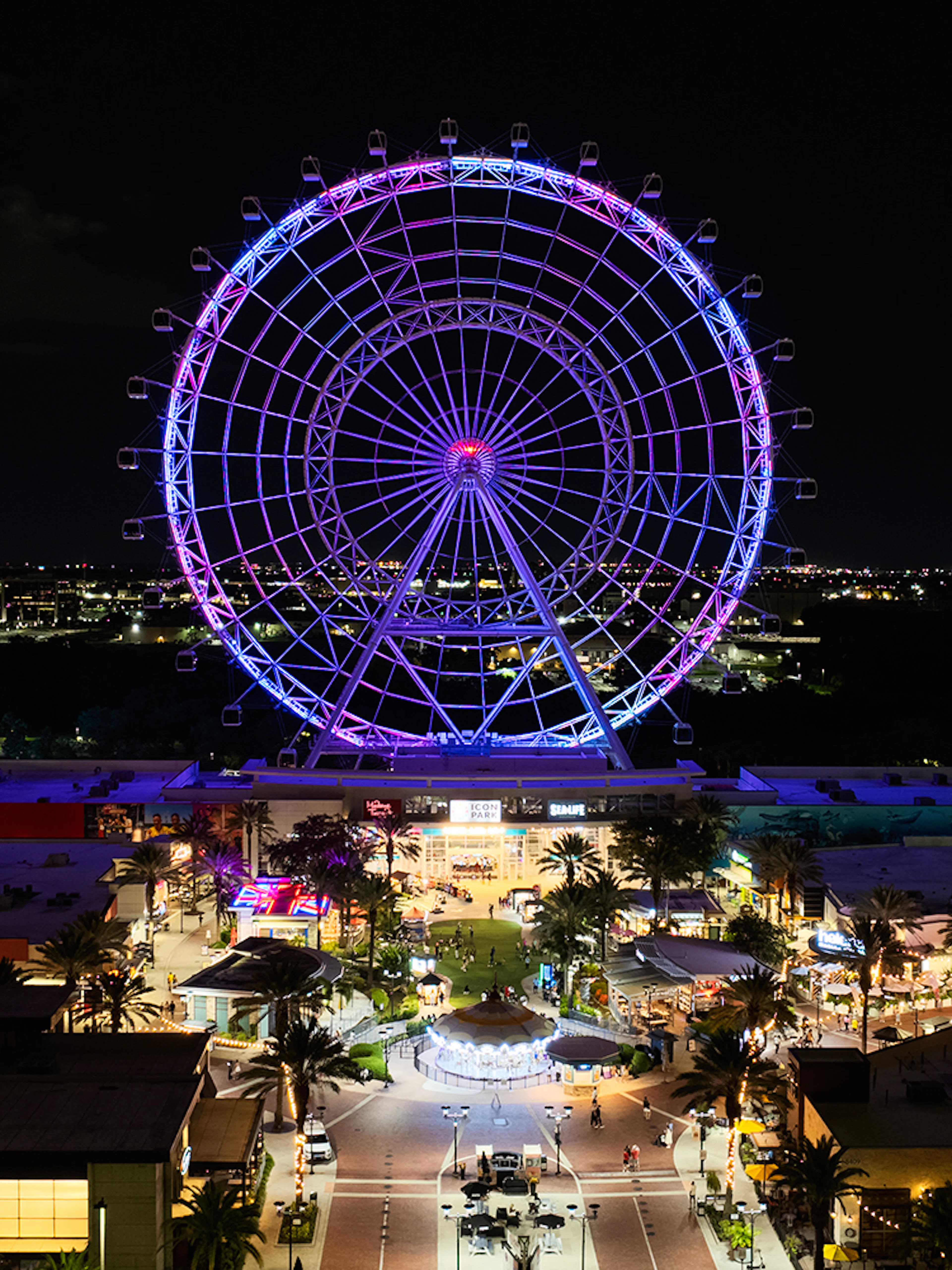 Ferris wheel illuminated at night in ICON Park, Orlando.