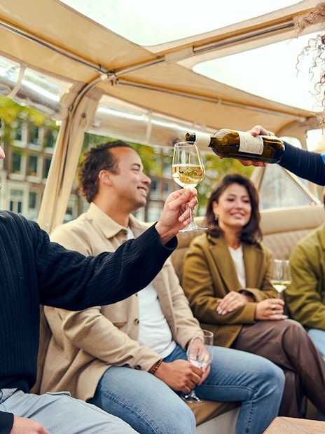 Guests enjoying wine on an evening candlelight cruise.