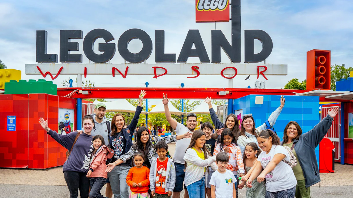 Visitors at the entrance of Legoland Windsor with the iconic sign overhead.