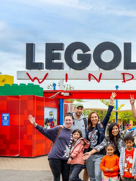 Visitors at the entrance of Legoland Windsor with the iconic sign overhead.