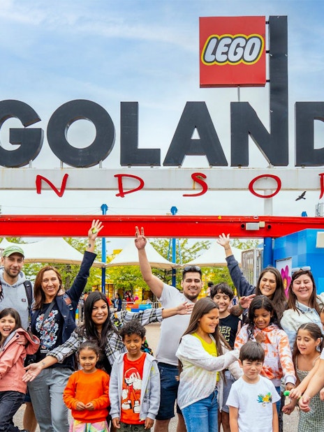 Visitors at the entrance of Legoland Windsor with the iconic sign overhead.