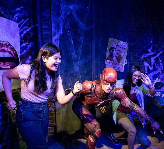 Visitors posing with Flash figure at Madame Tussauds Sydney.